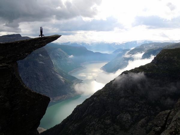 Стойка на голове на скале Язык тролля Норвегия